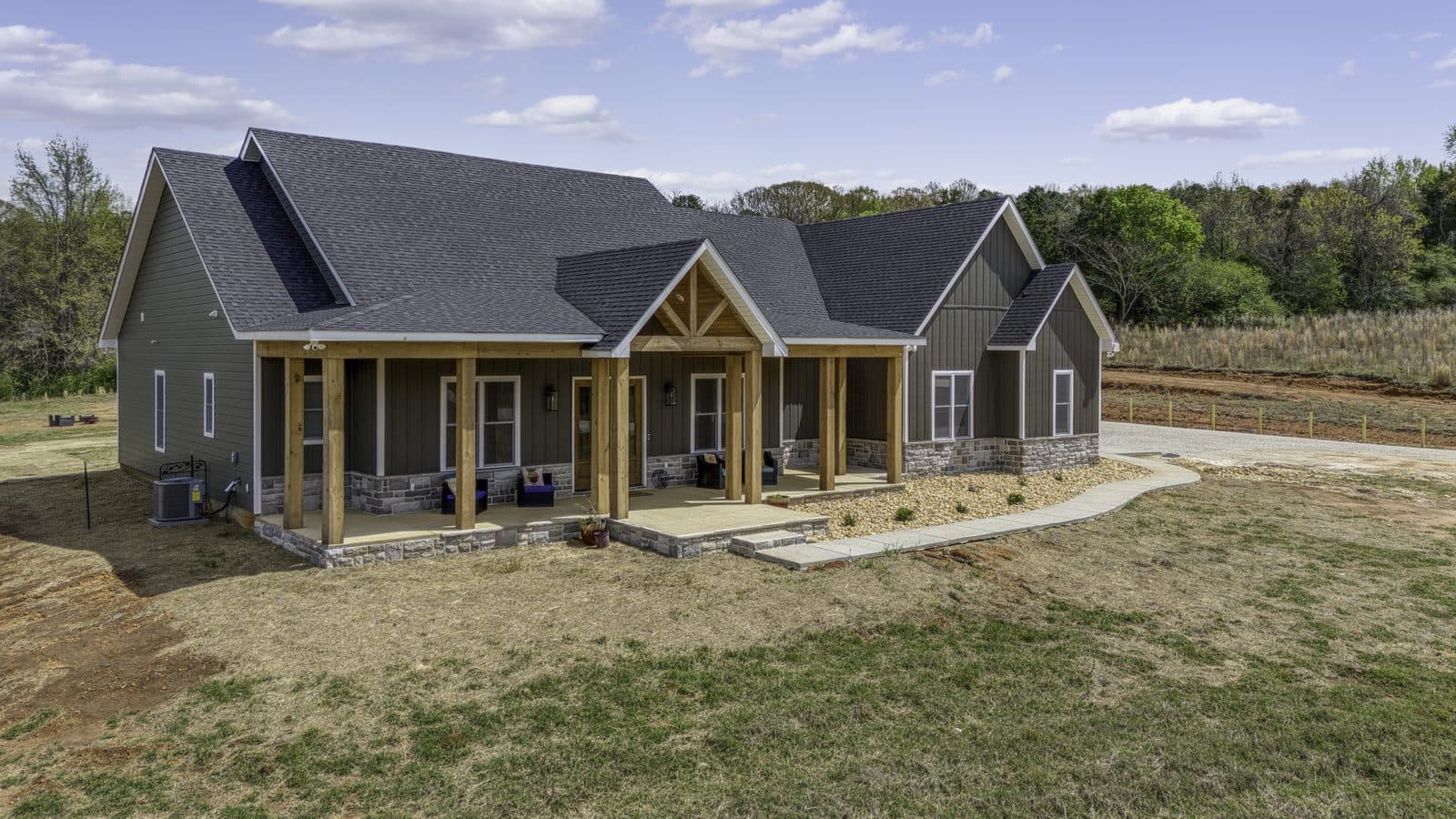 Stone Craftsman home with a gabled porch, cedar posts and stone skirting